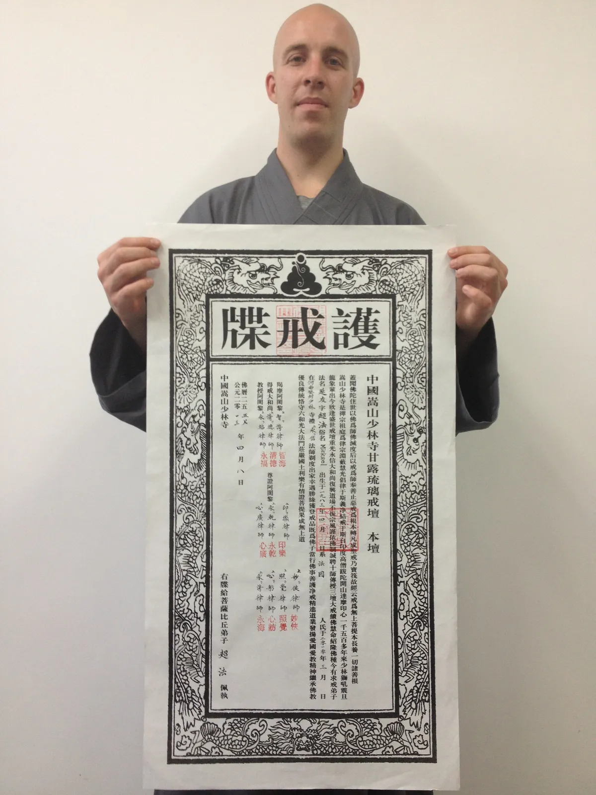 Maitre Shi Yan You tenant son certificat traditionnel d'ordination